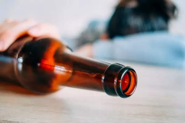 girl-sleeping-table-with-bottle-beer